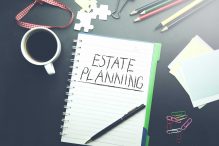 estate planning text on notepad  with stationary on table