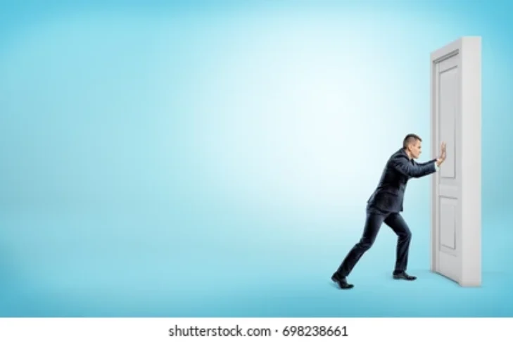 small-businessman-pushes-closed-door-260nw-698238661